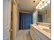 Bathroom with a double sink vanity, tiled floor, and a shower with a blue patterned curtain at 3517 Elk St, Burlington, NC 27215