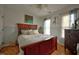 Cozy bedroom with a wooden bed frame, bright windows, wood floors, and two-tone walls at 3517 Elk St, Burlington, NC 27215