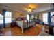 Spacious main bedroom features wood floors, a ceiling fan, an iron bed frame, and multiple windows at 3517 Elk St, Burlington, NC 27215