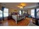 Spacious main bedroom features wood floors, a ceiling fan, an iron bed frame, and multiple windows at 3517 Elk St, Burlington, NC 27215