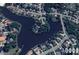 Aerial view of a lakeside neighborhood with large homes, mature trees, and a private lake at 4103 Cheek Point Pl, Burlington, NC 27215