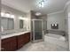 Elegant bathroom features a dual sink vanity, a tiled shower with glass door, and a soaking tub at 4103 Cheek Point Pl, Burlington, NC 27215