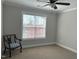 Simple bedroom featuring a window with blinds, neutral paint and carpet, and a vintage-style chair at 4103 Cheek Point Pl, Burlington, NC 27215