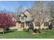 Inviting brick home featuring a well-manicured lawn and beautiful blossoming trees under a bright blue sky at 4103 Cheek Point Pl, Burlington, NC 27215