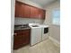 Functional laundry room with modern washer and dryer, sink, dark wood cabinets and neutral flooring at 4103 Cheek Point Pl, Burlington, NC 27215