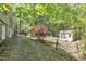 Secluded backyard with mature trees, a storage shed, and a gravel driveway at 480 Big Branch Dr, Pittsboro, NC 27312