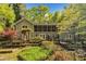 Charming home exterior showcasing a screened-in porch and wooden deck surrounded by lush greenery and mature trees at 480 Big Branch Dr, Pittsboro, NC 27312