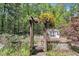 Landscaped backyard featuring a pergola adorned with flowering plants and a quaint storage shed at 480 Big Branch Dr, Pittsboro, NC 27312