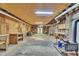 Spacious unfinished basement with wood-paneled walls, exposed ductwork, and a vintage wood-burning stove at 480 Big Branch Dr, Pittsboro, NC 27312