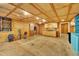 Open basement featuring plywood walls, and a small kitchen area with sink and storage at 480 Big Branch Dr, Pittsboro, NC 27312