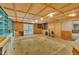 Open basement featuring plywood walls, built-in cabinets, desk, and glass doors to outside at 480 Big Branch Dr, Pittsboro, NC 27312