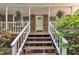 Welcoming front porch with hanging plants and brick accents, leading to a charming front door at 480 Big Branch Dr, Pittsboro, NC 27312