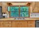 A kitchen sink with bright light through windows looks out onto lush green foliage at 480 Big Branch Dr, Pittsboro, NC 27312