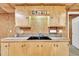 A charming kitchenette with wood cabinets, a stained-glass accent, and a black sink at 480 Big Branch Dr, Pittsboro, NC 27312