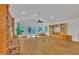 Open living room with a brick fireplace, hardwood flooring, built-in shelving, and sliding glass doors to an outdoor space at 480 Big Branch Dr, Pittsboro, NC 27312