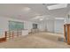 Bright living room with carpeted floors featuring a fireplace, a ceiling fan, windows and a built-in wooden shelving at 480 Big Branch Dr, Pittsboro, NC 27312