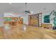 Open-concept living room with hardwood floors, brick fireplace, and seamless connection to the kitchen and dining area at 480 Big Branch Dr, Pittsboro, NC 27312