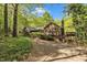 View of a brick home with a spacious wooden deck and wooded surroundings at 480 Big Branch Dr, Pittsboro, NC 27312