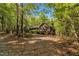 Brick home with wooded surroundings viewed from behind with a partial view of the deck at 480 Big Branch Dr, Pittsboro, NC 27312