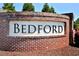 Brick sign at the entrance of the Bedford neighborhood, surrounded by lush greenery at 490 Mallard Loop Dr Dr, Clayton, NC 27527