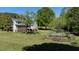 Spacious backyard with lush grass, garden area, mature trees and two-story home with deck at 530 Turlington Rd, Dunn, NC 28334