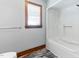 Full tub and shower in this bathroom with gray walls, tile floors and a wood-trimmed window at 530 Turlington Rd, Dunn, NC 28334