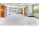 Large bedroom with plush carpet, a ceiling fan, ample natural light, and wood trim at 530 Turlington Rd, Dunn, NC 28334