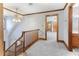 Hallway with gray plush carpet, a wooden banister, and views into other bedrooms and bathrooms at 530 Turlington Rd, Dunn, NC 28334