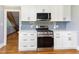 Well-lit kitchen with modern appliances, stylish cabinetry, and hardwood floors at 530 Turlington Rd, Dunn, NC 28334