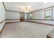 Large living room with plush carpeting, wood trim, and multiple windows at 530 Turlington Rd, Dunn, NC 28334