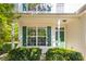 Inviting front porch with green shutters and matching door complemented by lush greenery and manicured bushes at 6 Dawson Ct Ct, Durham, NC 27703