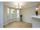 Bright dining area with a bay window, chandelier, and wood flooring, next to the kitchen at 6022 Four Townes Lane Ln, Raleigh, NC 27616