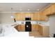 Well-lit kitchen featuring wooden cabinets, black appliances, and a bright white countertop at 6022 Four Townes Lane Ln, Raleigh, NC 27616