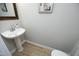 Charming powder room with pedestal sink and wood-look tile flooring at 6022 Four Townes Lane Ln, Raleigh, NC 27616