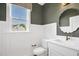 Well-lit powder room featuring modern fixtures, wainscoting, and elegant mirror at 67 Farmstead Ct, Wendell, NC 27591