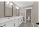 Bright bathroom featuring double vanity with black hardware, and a doorway leading to a toilet at 67 Farmstead Ct, Wendell, NC 27591