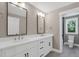 This bathroom features a double vanity with storage, large mirrors, and a gray tile floor at 67 Farmstead Ct, Wendell, NC 27591