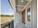 Open view from a covered porch featuring paneled ceiling, double doors, and black metal railing at 67 Farmstead Ct, Wendell, NC 27591