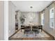 Stylish dining room featuring wainscoting, a modern chandelier, and access to the bar and kitchen at 67 Farmstead Ct, Wendell, NC 27591