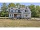 Beautiful two-story home featuring a manicured lawn and a symmetrical facade and covered porch at 67 Farmstead Ct, Wendell, NC 27591