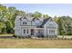 Charming two-story home with a manicured lawn and covered porch, surrounded by lush trees at 67 Farmstead Ct, Wendell, NC 27591