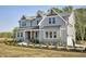 Charming two-story home with gray siding, stone accents, manicured landscaping, and a walkway at 67 Farmstead Ct, Wendell, NC 27591