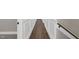 This hallway features light-colored walls with moulding, a wooden handrail, and wood floors at 67 Farmstead Ct, Wendell, NC 27591