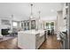 Open-concept kitchen and living room with a white quartz island, stylish lighting, and fireplace at 67 Farmstead Ct, Wendell, NC 27591