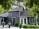 Attractive home exterior with blue siding, white trim, decorative accents, complemented by lush landscaping and a cozy outdoor seating area at 6765 Rock Service Station Rd Rd, Raleigh, NC 27603
