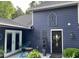 Charming front exterior with dark siding, decorative windows, front door with wreath, and stylish outdoor furniture at 6765 Rock Service Station Rd Rd, Raleigh, NC 27603