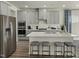 Modern kitchen with stainless steel appliances, gray cabinets, a white countertop island, and bar stool seating at 708 Deschutes Dr, Garner, NC 27529
