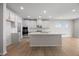 Spacious kitchen featuring modern white cabinets, an island with bar seating, and stainless steel appliances at 708 Deschutes Dr, Garner, NC 27529