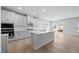 Modern kitchen with gray cabinets, a central island, stainless steel appliances, and hardwood floors at 708 Deschutes Dr, Garner, NC 27529