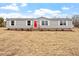 Inviting single-story home with a red door, gray siding, and a spacious front yard at 7289 Nc 561, Louisburg, NC 27549